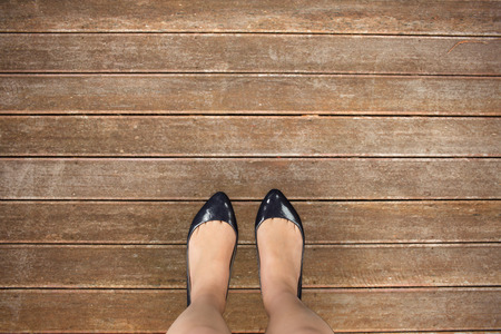 Businesswomans feet against wooden planks backgroundの写真素材