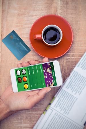World credit card against overhead view of person using smart phone by coffeeの写真素材