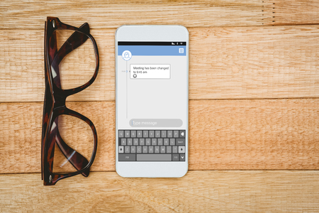 Smartphone text messaging  against view of glasses and a smartphoneの写真素材