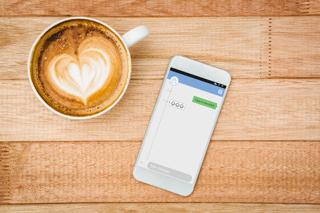Smartphone text messaging  against view of a heart composed of coffeeの写真素材