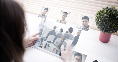 Business people having a meeting  against woman using tablet at deskの写真素材