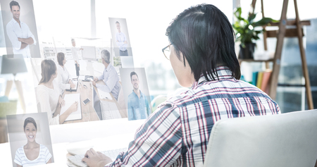 Business people having a meeting  against rear view of businessman using computerの写真素材