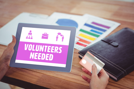 Yellow volunteers needed against over shoulder view of hipster woman using tabletの写真素材