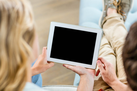 Couple using a tablet computer in the living room