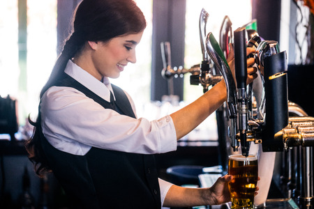 Barmaid serving a pint in a bar
