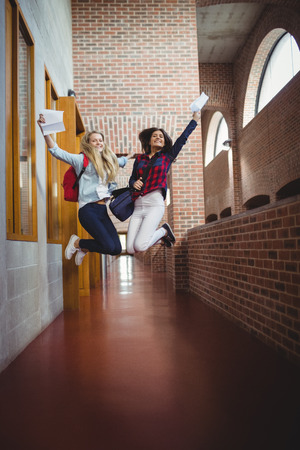 Happy female students receiving results at the universityの写真素材