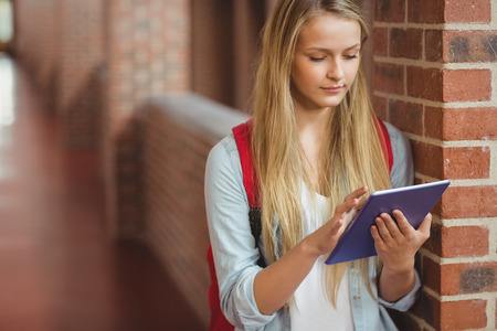 Student using tablet in the hallway at universityの写真素材
