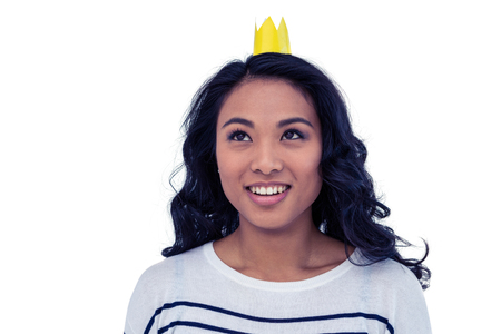 Smiling Asian woman with paper crown on white screenの写真素材