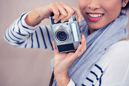 Close up of smiling Asian woman taking photograph with camera