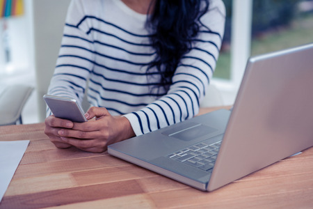 Close up of woman using smartphone in officeの写真素材