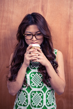 Asian woman wearing eyeglasses holding disposable cupの写真素材