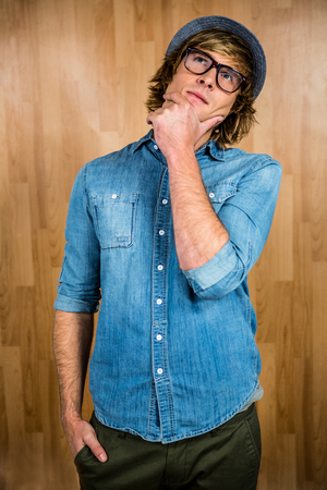 Close up of hipster man thinking with wooden backgroundの写真素材
