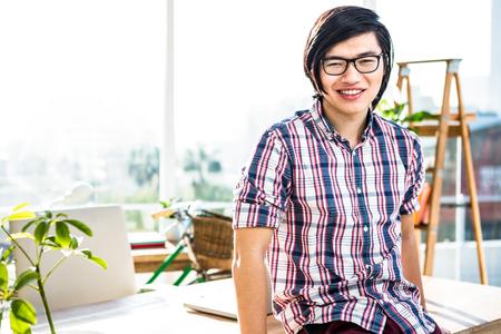 Smiling hipster businessman posing for camera in officeの写真素材