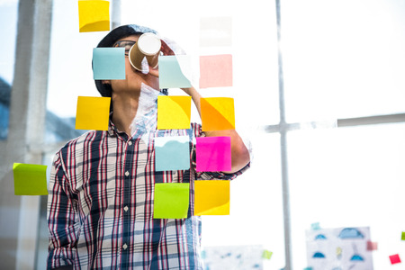 Creative businessman drinking coffee in officeの写真素材