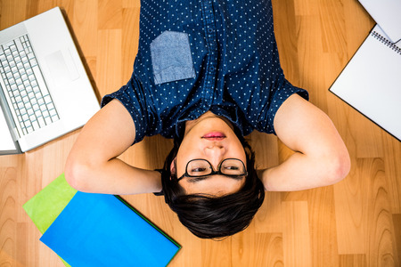 Hipster businessman lying on floor in officeの写真素材