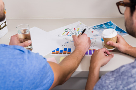 Two businessmen working on graphs in office