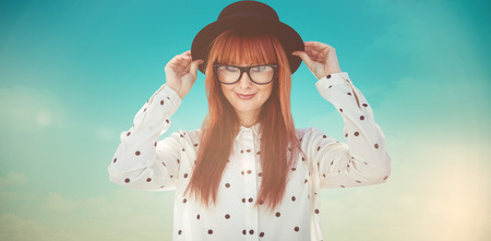 Attractive smiling hipster woman with hat  against blue green backgroundの写真素材