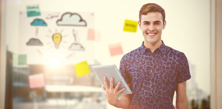 Handsome man with tablet against adhesive notes on windowの写真素材