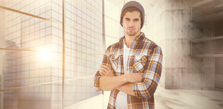 Portrait of confident hipster with arms crossed against modern room overlooking cityの写真素材