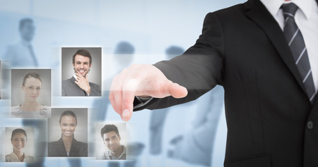 Businessman in suit pointing his finger against blue backgroundの写真素材