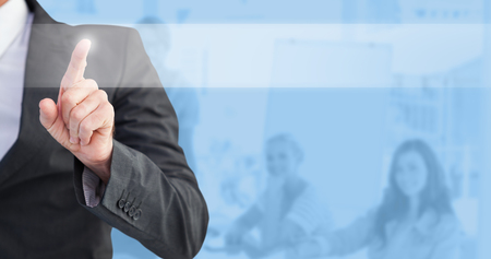 Businessman pointing his finger at camera against blue backgroundの写真素材