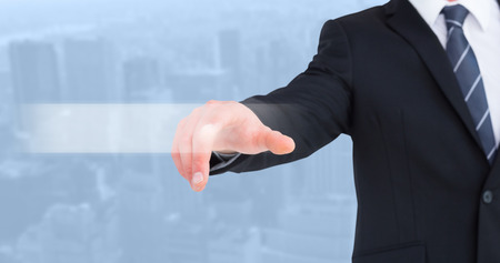 Businessman in suit pointing his finger against view of cityscapeの写真素材