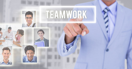 Businessman touching invisible screen against low angle view of city buildingsの写真素材