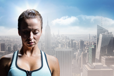 Sad athlete woman in sportswear against sunny city viewの写真素材
