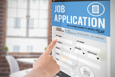 Female hand pointing against laptop on desk with glasses and notepadの写真素材