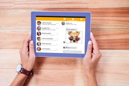 Smartphone app menu against overhead of feminine hands using tabletの写真素材
