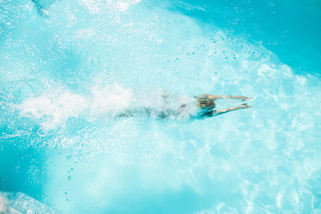 Overhead of woman diving in the pool