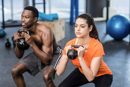 Athletic man and woman working out at crossfit gymの写真素材
