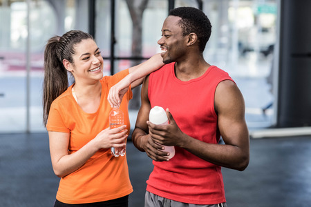 Smiling woman and man after effort at crossfit gymの写真素材