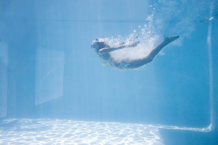 Fit woman swimming under water in the poolの写真素材
