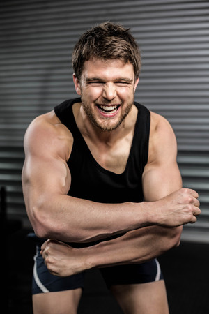 Smiling fit man screaming at crossfit gymの写真素材