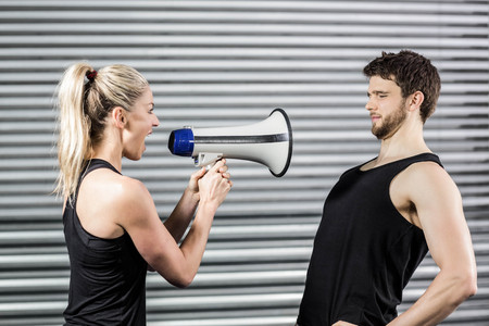 Trainer yelling through the megaphone at crossfit gymの写真素材