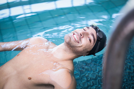 Handsome man resting in the water in the poolの写真素材