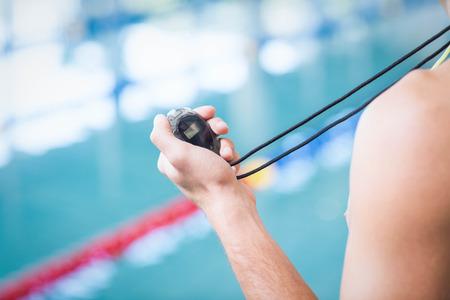 Trainer holding stopwatch at the poolの写真素材
