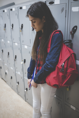 Sad student leaning on locker at universityの写真素材