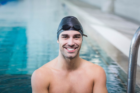 Handsome man getting out of water at the pool