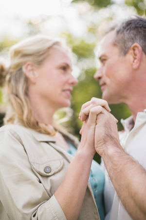 Cute couple dancing and holding hands outsideの写真素材