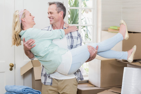 Happy husband carrying his wife in their new house