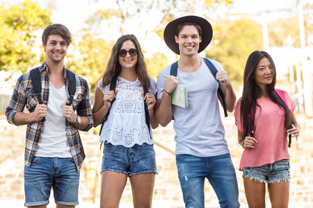 Hip friends walking and holding a map on the streets