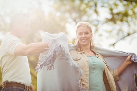 Husband putting a blanket around his wife outsideの写真素材