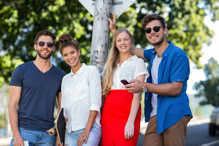 Hip friends smiling at the camera outdoors