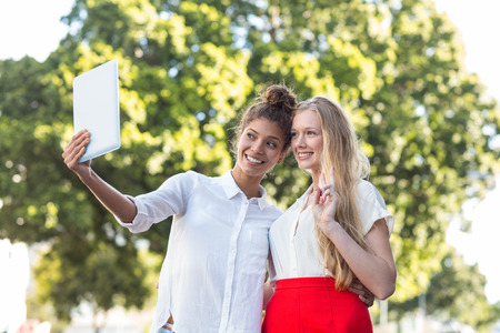 Hip friends taking selfies with tablet in the streetsの写真素材
