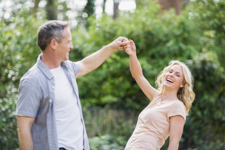 Cute couple holding hands outside in the forestの写真素材