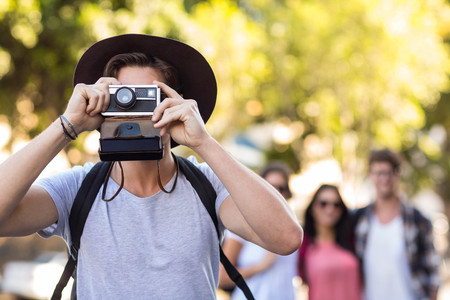 Hip man taking picture with polaroid in the cityの写真素材