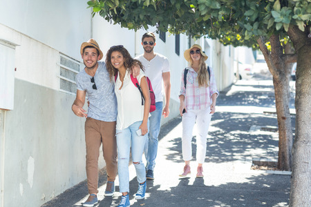 Hip friends walking on the street and smiling at the cameraの写真素材