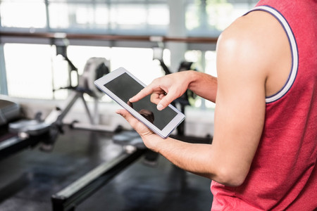 Mid section of man using tablet in the gymの写真素材